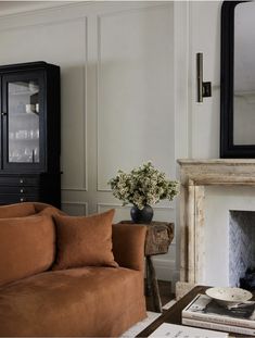 a living room filled with furniture and a fire place in front of a large mirror