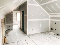 an empty room with white paint on the walls and flooring being installed in it