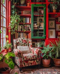 a living room filled with lots of plants and bookshelves next to a window