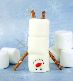 marshmallows and cinnamon sticks are arranged in the shape of a snowman