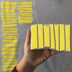 someone is holding up some yellow strips of paper