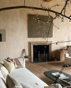 a living room filled with furniture and a tree branch in the middle of the room