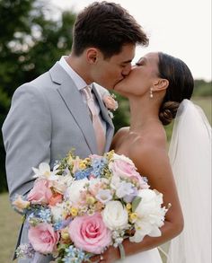 a bride and groom kissing each other in front of the camera on their wedding day