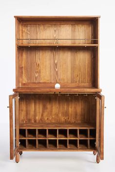 an old wooden cabinet with wine bottles on the bottom shelf and shelves below it, against a white background