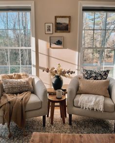 a living room with two couches and a coffee table in front of large windows