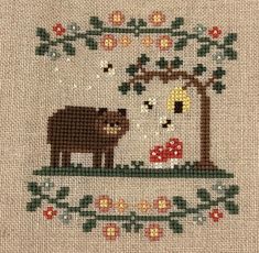 a cross stitch pattern with an animal and tree