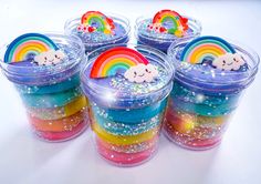 four plastic containers filled with rainbow colored jellopops and a white bear on top