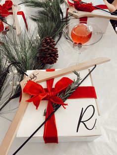 the table is set up with pine cones and wine glasses for an elegant holiday celebration