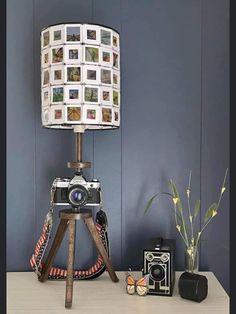 a lamp that is sitting on top of a table next to a camera and other items