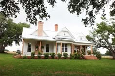 a white house sitting on top of a lush green field