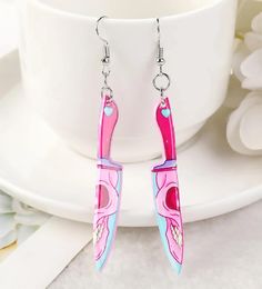 Add a touch of edgy style to your look with these unique Skull Knife Earrings. Made with durable materials, these earrings feature a bold and eye-catching design that is sure to make a statement. Available in pink and green, these earrings are the perfect accessory for those who want to stand out from the crowd. Add them to your cart now and elevate your style! Skeleton Knife, Pastel Goth Earrings, Skull Knife, Knife Earrings, Pastel Skull, Goth Halloween, Goth Earrings, Bone Earrings, Me And My Dog