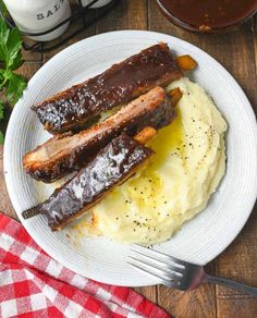 two pieces of ribs on top of mashed potatoes