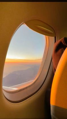 an airplane window looking out at the mountains