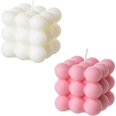 two pink and white candles sitting next to each other