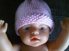 a baby doll wearing a pink knitted hat