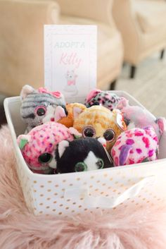 a basket filled with lots of small stuffed animals sitting on top of a pink rug