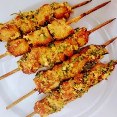 several skewers of food on a white plate