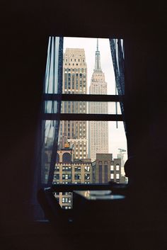 the view from inside a window looking at skyscrapers