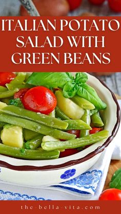 a bowl filled with green beans and tomatoes on top of a blue and white napkin