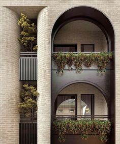 an apartment building with plants growing on the balconies