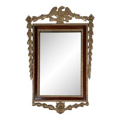 a mirror that is sitting on top of a wooden frame with an eagle and leaves design