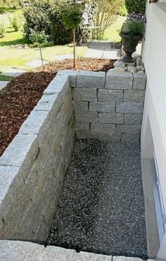 an outdoor fire pit in the middle of a yard with rocks and gravel around it