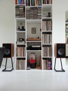 there are many bookshelves and speakers in this room