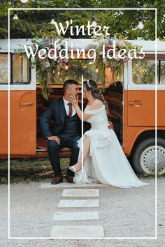 a bride and groom sitting on a bench in front of an orange bus