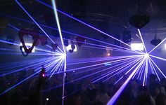 a group of people in a room with laser lights