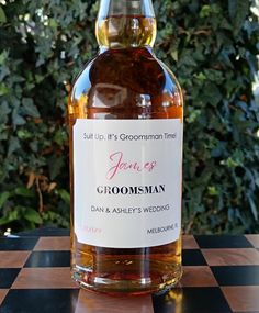 a bottle of groomsman's whiskey sitting on top of a checkered table