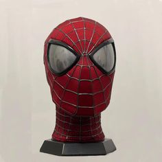 a close up of a spiderman mask on a white background with the eyes open