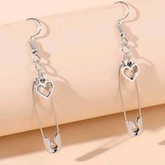 Silver-Tone Dangle Earrings Featuring Safety Pins & Hearts Eardrop Height: 2.4 In (6.2 Cm) Eardrop Width: 0.5 In (1.3 Cm) Tags Goth Gothic Emo Punk Edgy Grunge Valentine's Day Love 60s 70s 80s 90s 00s Y2k Kawaii Rave Beach Retro Vintage Gypsy Summer Rock And Roll Vamp Vampire Hot Topic Dolls Kill Killstar Party Cosplay Costume Halloween Club Chic Bohemian Boho Hippy Hippie Festival Concert Artsy Artistic Contemporary Modern Trendy Trending Metal Casual Safety Pin Heart, Halloween Club, Hello Kitty Earrings, Beach Retro, Y2k Kawaii, Edgy Grunge, Gothic Emo, Pin Earrings, Safety Pin Earrings