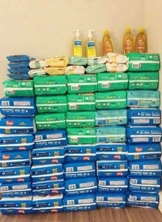 stacks of blue and green boxes stacked on top of each other in front of a white wall