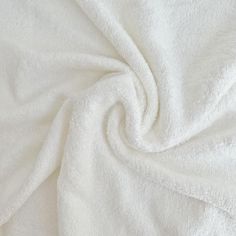 a white blanket that is laying on top of a bed