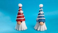 two snowmen made out of tassels on a blue background