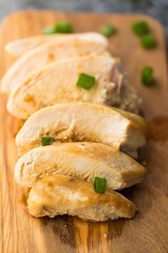 sliced chicken on a cutting board with green onions