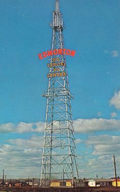 a tall tower sitting on the side of a road next to a train track and grass covered field