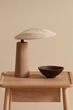 a wooden table with a bowl on it and an object sitting on top of it