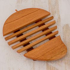 a wooden comb sits on top of a white table with wood strips in the shape of a face