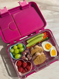 a pink lunch box filled with fruits and vegetables