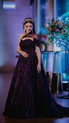 a woman in a purple dress standing on a stage with her hands on her hips