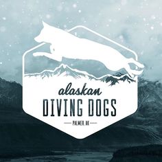 the alaska diving dogs logo is shown in white and blue, with mountains behind it