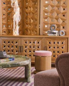 a living room filled with furniture and a wooden book shelf next to a table covered in books