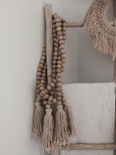 an old ladder is decorated with wooden beads and tassels for decorating the bedroom