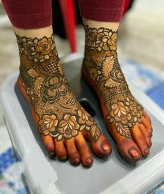 a woman with henna on her feet standing on a scale