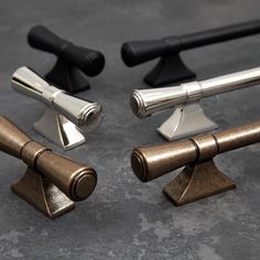 three different types of metal objects on a table top with black handles and silver tips