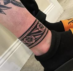 a person's foot with a tattoo on it and an orange shoe next to them