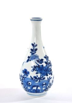 a blue and white vase with flowers on it