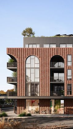 an apartment building with arched windows and balconies on the second floor is made of red brick