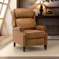 a brown recliner chair sitting on top of a rug in front of a window